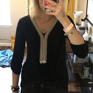 Black quarter-length sleeve top with neck design.